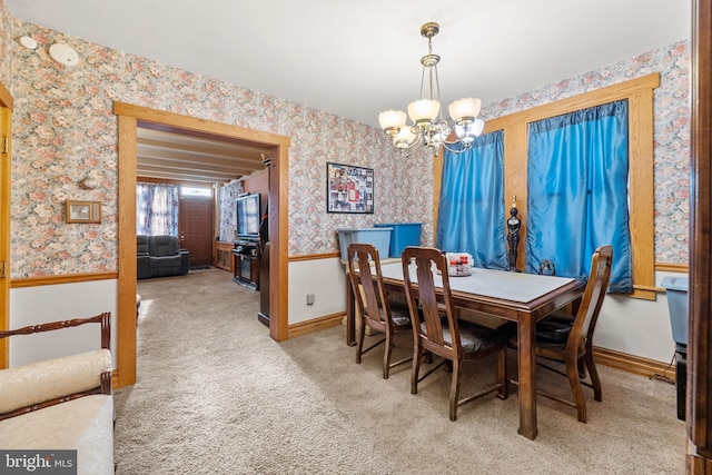 dining room featuring light colored carpet and a chandelier