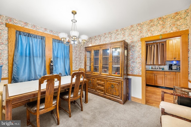 carpeted dining area with a chandelier