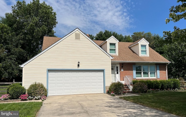 cape cod house featuring a garage and a front yard