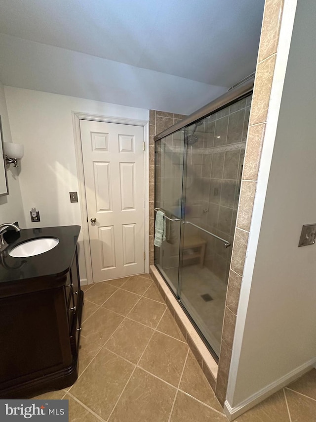 bathroom featuring tile patterned floors, walk in shower, and vanity