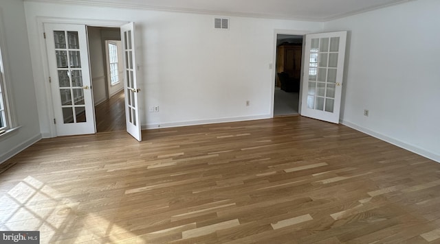 empty room with french doors, crown molding, and dark hardwood / wood-style flooring