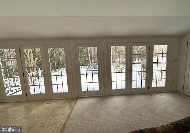 doorway to outside with plenty of natural light and light carpet