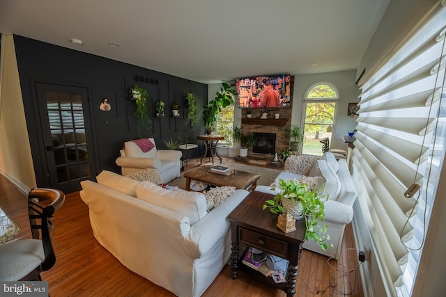 living room with hardwood / wood-style flooring and a brick fireplace