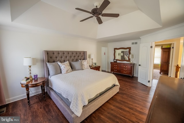 bedroom featuring a tray ceiling, dark wood-type flooring, ornamental molding, and ceiling fan