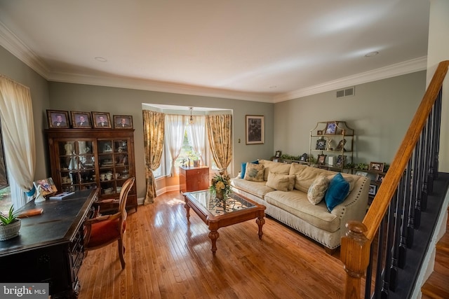 living room with hardwood / wood-style flooring and crown molding