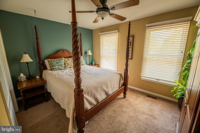 carpeted bedroom with ceiling fan and multiple windows