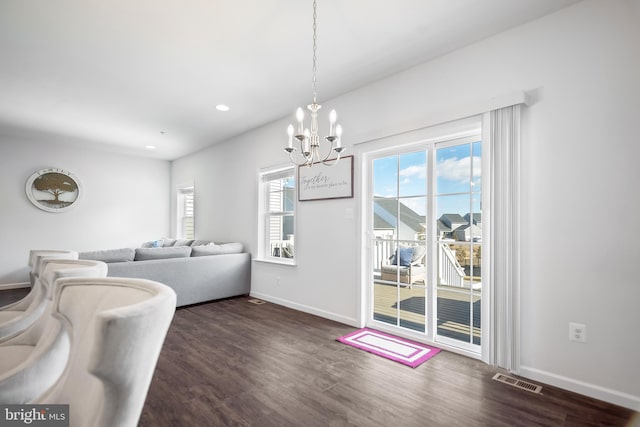 dining area featuring an inviting chandelier and dark hardwood / wood-style flooring