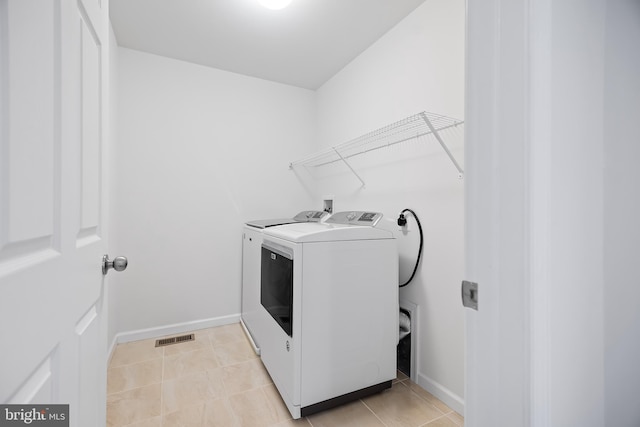 washroom with light tile patterned flooring and separate washer and dryer