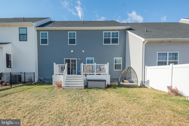 rear view of house with a lawn and a deck