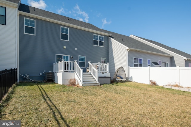 rear view of house featuring central air condition unit, a deck, and a lawn