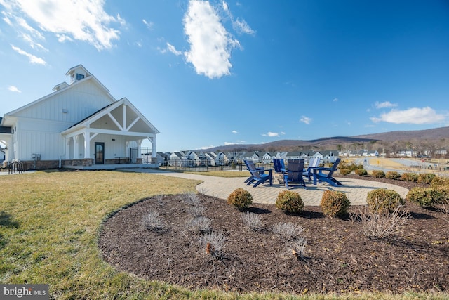 exterior space with a lawn, a patio, and a mountain view