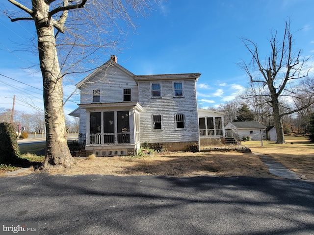 rear view of property featuring a sunroom