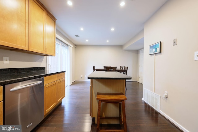 kitchen with a kitchen breakfast bar, stainless steel dishwasher, dark hardwood / wood-style floors, and a kitchen island