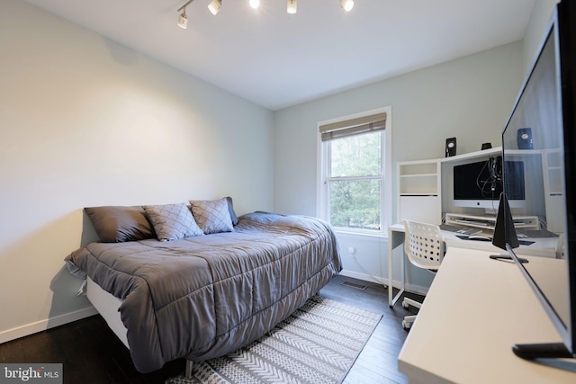 bedroom featuring wood-type flooring and rail lighting