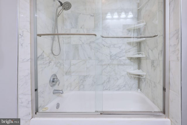 bathroom with bath / shower combo with glass door