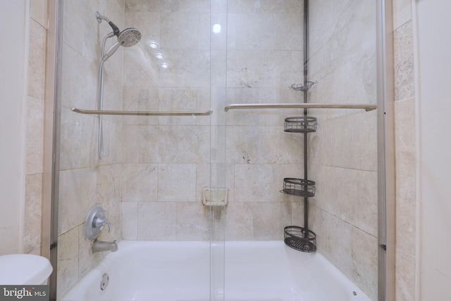 bathroom featuring enclosed tub / shower combo and toilet