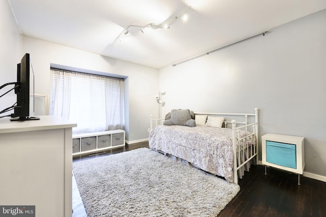 bedroom featuring dark hardwood / wood-style flooring and track lighting