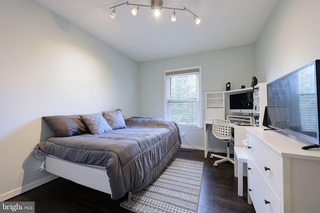 bedroom featuring dark wood-type flooring, track lighting, and vaulted ceiling