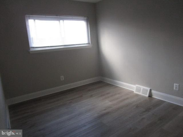 unfurnished room with dark wood-type flooring