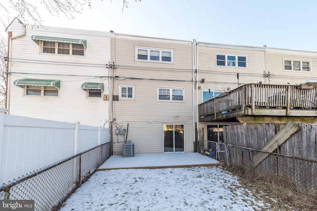 snow covered rear of property featuring cooling unit