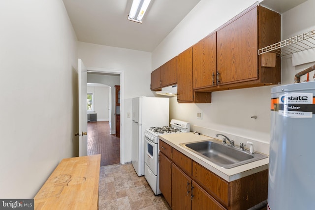 kitchen with white range with gas stovetop, sink, and secured water heater