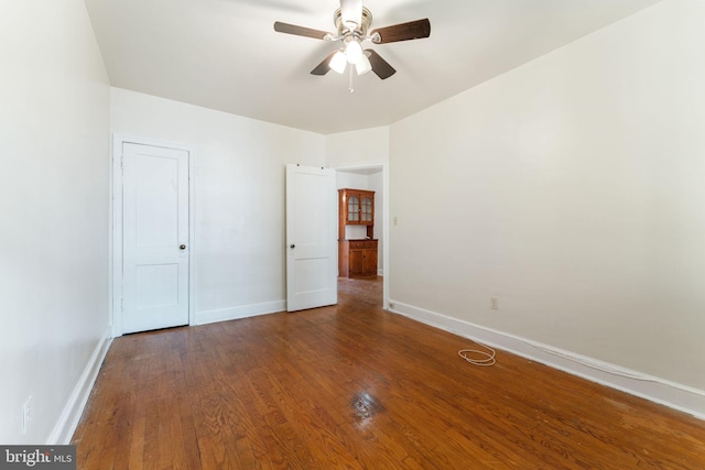 unfurnished bedroom with ceiling fan and dark hardwood / wood-style flooring