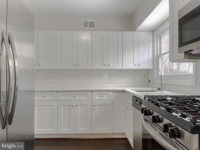 kitchen featuring white cabinets, stainless steel appliances, and sink