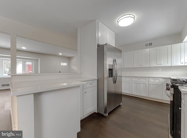 kitchen with kitchen peninsula, white cabinets, dark hardwood / wood-style floors, and stainless steel appliances