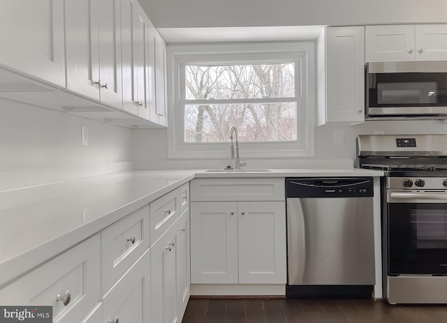 kitchen with sink, white cabinets, and appliances with stainless steel finishes