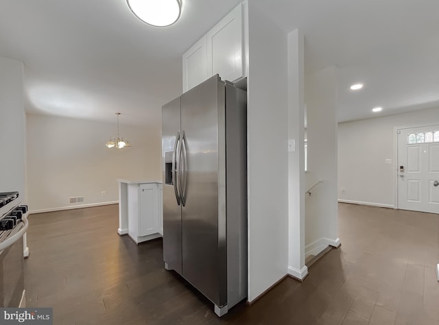 kitchen featuring white cabinetry, dark hardwood / wood-style flooring, stainless steel appliances, an inviting chandelier, and hanging light fixtures