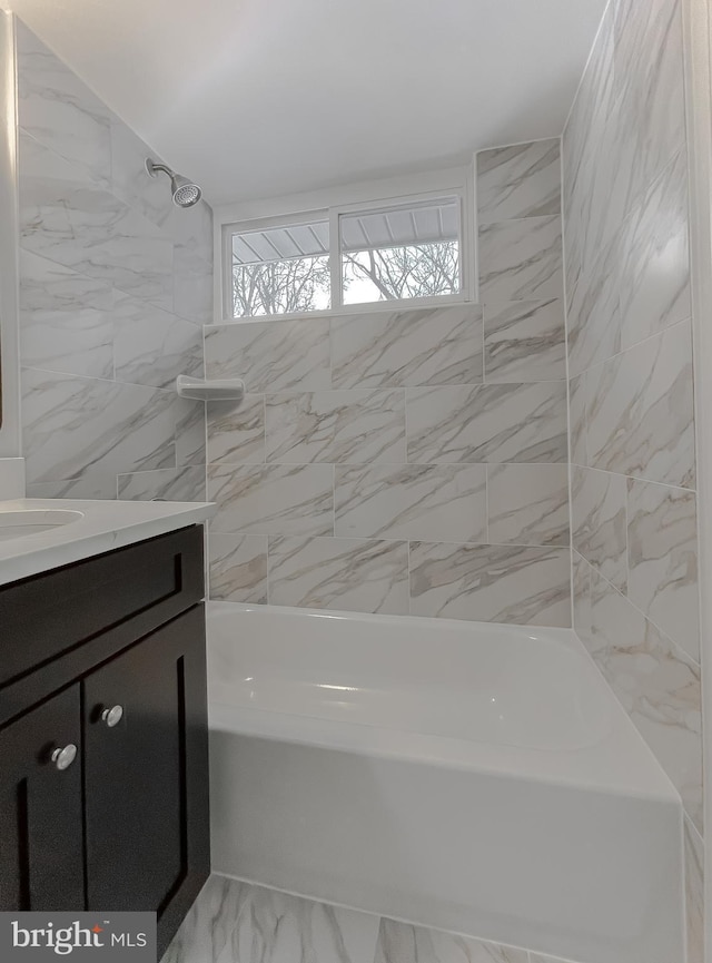 bathroom with tiled shower / bath and vanity