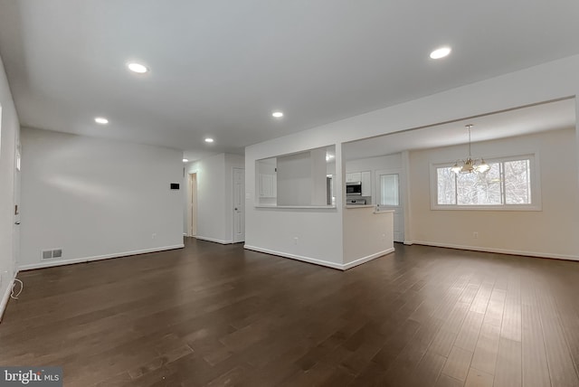 unfurnished living room with dark hardwood / wood-style flooring and a notable chandelier