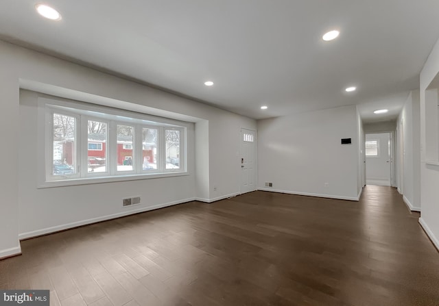 interior space with plenty of natural light and dark hardwood / wood-style flooring