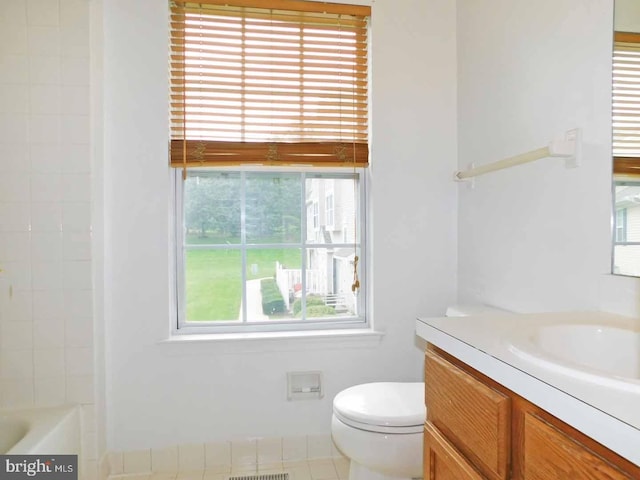 bathroom with toilet, tile patterned floors, a wealth of natural light, and vanity