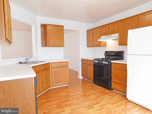 kitchen featuring light wood-type flooring, sink, kitchen peninsula, gas stove, and white refrigerator