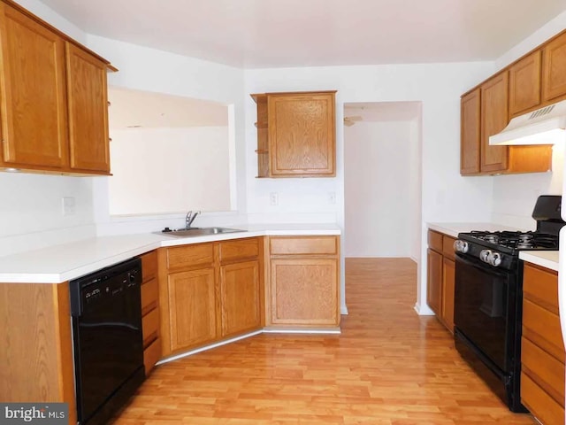 kitchen with black appliances, light hardwood / wood-style flooring, and sink