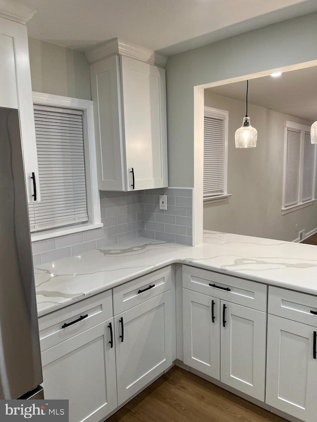 kitchen featuring backsplash, white cabinetry, and pendant lighting