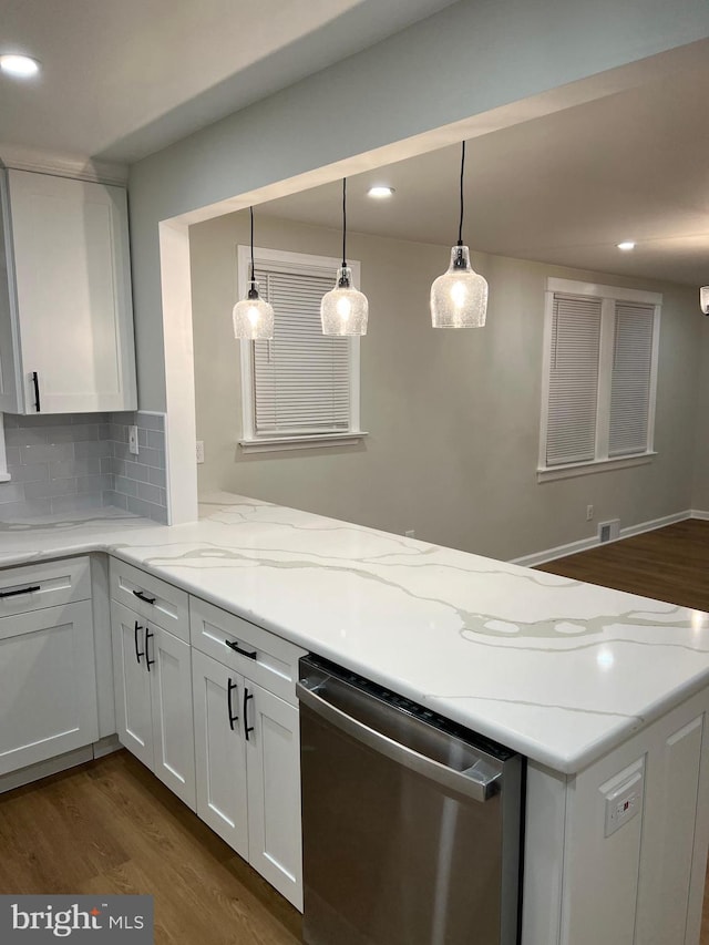 kitchen with white cabinets, light stone counters, stainless steel dishwasher, and tasteful backsplash