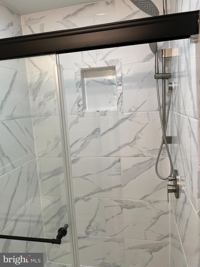 bathroom with a shower with door