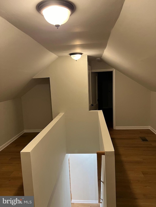 hallway featuring dark hardwood / wood-style floors and vaulted ceiling