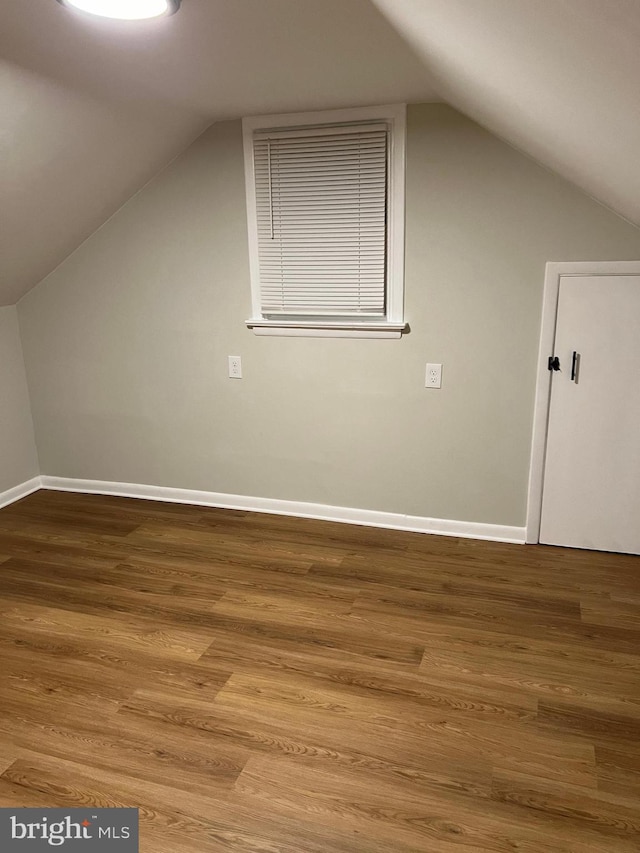 bonus room with hardwood / wood-style flooring and vaulted ceiling