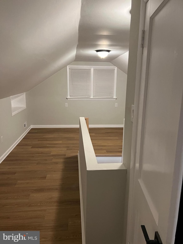 additional living space featuring dark hardwood / wood-style flooring and lofted ceiling