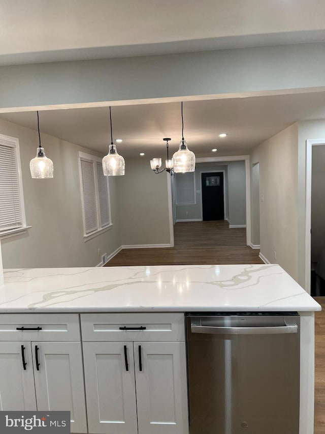 kitchen with light stone counters, white cabinets, decorative light fixtures, and stainless steel dishwasher