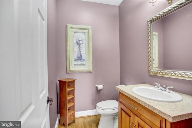 bathroom featuring vanity, hardwood / wood-style floors, and toilet