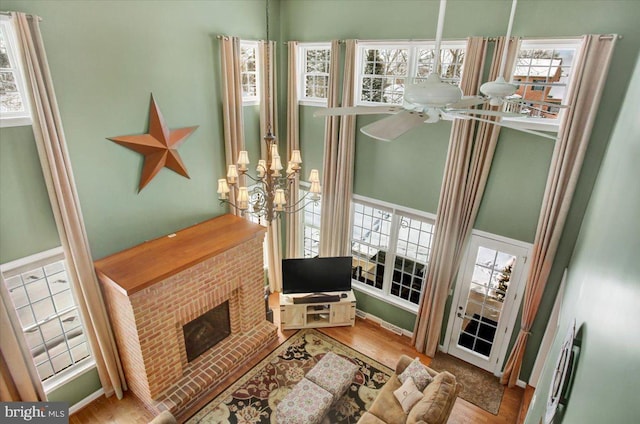 living room with ceiling fan, a healthy amount of sunlight, a fireplace, and light hardwood / wood-style floors