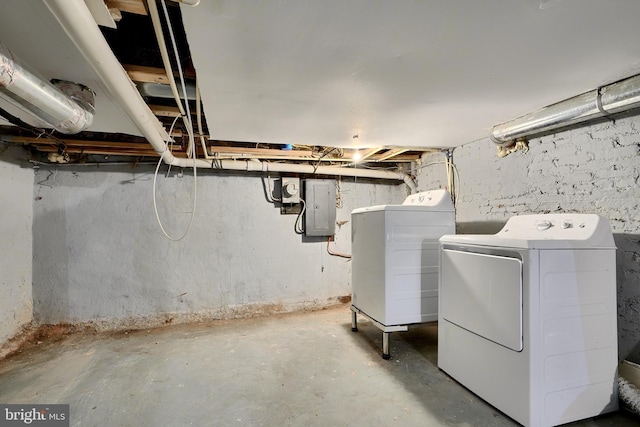 basement with washing machine and clothes dryer and electric panel