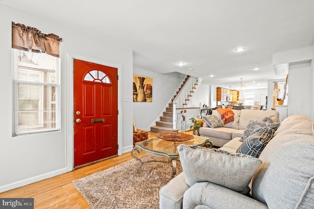 living room with light hardwood / wood-style flooring and a notable chandelier