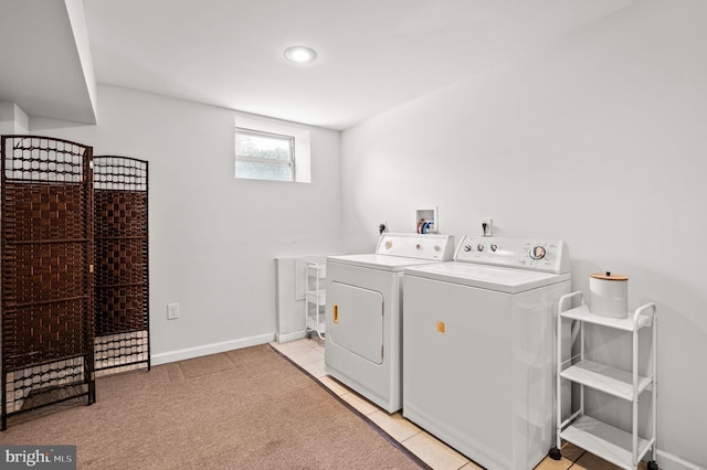 clothes washing area featuring washing machine and dryer and light tile patterned flooring