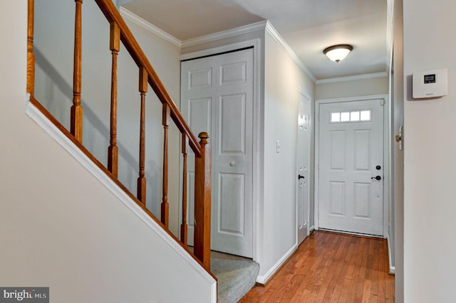 entrance foyer featuring ornamental molding and light wood-type flooring