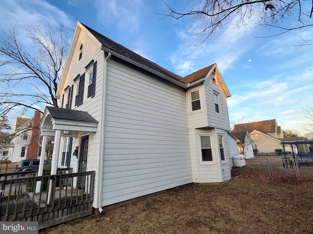 view of side of home featuring fence